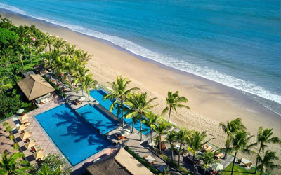 A three-tier pool separates the resort from the yellow sand beach of Seminyak.