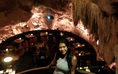 Olivia on the stairs into the cave with the dinner tables in the distance.